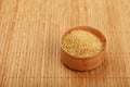 Wooden bowl of brown cane sugar on bamboo mat Royalty Free Stock Photo