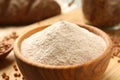 Wooden bowl of buckwheat flour on board