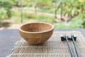 Wooden bowl with chopsticks on bamboo mat on wooden table in the garden Royalty Free Stock Photo