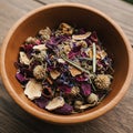 A wooden bowl containing a mix of dried flowers and botanical elements. The Royalty Free Stock Photo