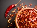 Wooden bowl of crushed red pepper, Cayenne pepper, dried chilli on a motley background. It is a popular spicy Royalty Free Stock Photo