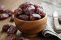 Wooden bowl of dates fruits and knife.