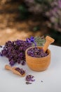 Wooden bowl with dried lavender on field background. Flower herbal tea drink. Aromatherapy, medicine ingredient. Calming beverage Royalty Free Stock Photo