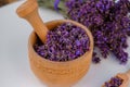 Wooden bowl with dried lavender on field background. Flower herbal tea drink. Aromatherapy, medicine ingredient. Calming beverage Royalty Free Stock Photo