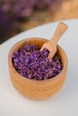 Wooden bowl with dried lavender on field background. Flower herbal tea drink. Aromatherapy, medicine ingredient. Calming beverage Royalty Free Stock Photo