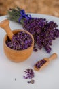 Wooden bowl with dried lavender on field background. Flower herbal tea drink. Aromatherapy, medicine ingredient. Calming beverage Royalty Free Stock Photo