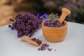 Wooden bowl with dried lavender on field background. Flower herbal tea drink. Aromatherapy, medicine ingredient. Calming beverage Royalty Free Stock Photo