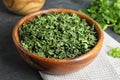 Wooden bowl of dried parsley on table Royalty Free Stock Photo