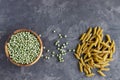 A wooden bowl with dry green peas and a row of pasta, pea pasta. Vegetarian food from vegetables. Place for text Royalty Free Stock Photo