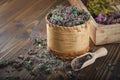 Wooden bowl of dry wild Marjoram or Origanum vulgare plants, wooden crate of medicinal herbs.