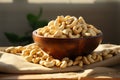 Wooden bowl filled with cashew nuts atop a burlap canvas