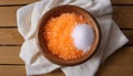 A wooden bowl filled with orange sugar and a white substance