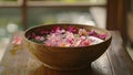 A wooden bowl filled with water and floating flower petals used in Thai traditional healing ceremonies known as Luk Pra