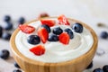 Wooden bowl filled with yoghurt, strawberries and blueberries in detail Royalty Free Stock Photo