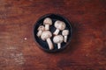 Wooden bowl of fresh raw champignon mushrooms on kitchen table. Autumn harvest, seasonal organic vegan food, healhty eating. Copy