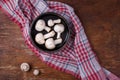 Wooden bowl of fresh raw champignon mushrooms on red kitchen towel. Autumn harvest, seasonal jrganic vegan food, healhty eating