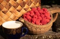 Wooden bowl with fresh ripe rasberries and a glass of milk