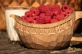 Wooden bowl with fresh ripe rasberries and a glass of milk