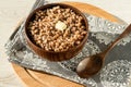 In a wooden bowl, freshly brewed delicious healthy buckwheat porridge with butter for breakfast on a linen napkin with a spoon.