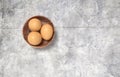 Wooden bowl ful of eggs. Placed on concrete table.