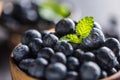 Wooden bowl full of fresh blueberries with herbs Royalty Free Stock Photo