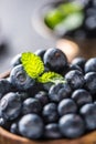 Wooden bowl full of fresh blueberries with herbs Royalty Free Stock Photo