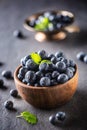 Wooden bowl full of fresh blueberries with herbs Royalty Free Stock Photo