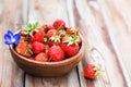 Wooden bowl full of fresh strawberries on thewooden background