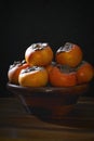 Wooden bowl full of persimmons