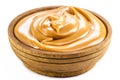 Wooden bowl with homemade dulce de leche, condensed cream or pasty caramel, isolated white background