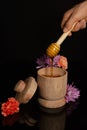 Wooden bowl with honey dipper dripping honey with flowers Royalty Free Stock Photo