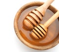 Wooden bowl with honey and dippers on white background