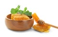 Wooden bowl with honeycomb, dipper and mint on white background