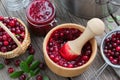 Bowl and jar of crushed cranberries, jam or sauce, basket of bog berries and strainer. Top view. Royalty Free Stock Photo