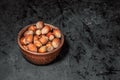 Wooden bowl with mixed nuts on dark background