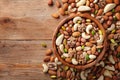 Wooden bowl with mixed nuts on rustic table top view. Healthy food and snack
