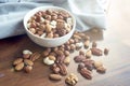 Wooden bowl with mixed nuts on table top view. Healthy food and snack. Walnut, pistachios, almonds, hazelnuts and Royalty Free Stock Photo