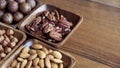 Wooden bowl with mixed nuts on table top view. Healthy food and snack. Walnut, pistachios, almonds, hazelnuts and Royalty Free Stock Photo