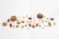 Wooden bowl with mixed nuts on white table top view. Healthy food and snack. Walnut, pistachios, almonds, hazelnuts