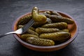 Wooden bowl of pickled cucumbers with fork on black table, closeup Royalty Free Stock Photo