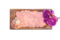 Wooden bowl with pink sea salt with seashell and purple orchid. Spa. White background