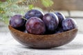 Wooden bowl of plums