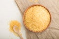 Wooden bowl with raw golden rice and wooden spoon on a white wooden background. Top view, close up Royalty Free Stock Photo