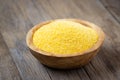 Wooden bowl with raw polenta on wooden table Royalty Free Stock Photo