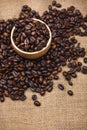 Wooden bowl with roasted coffee beans on rustic background. Royalty Free Stock Photo