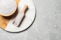 Wooden bowl and scoop with natural sea salt on light grey table, top view. Space for text Royalty Free Stock Photo