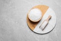 Wooden bowl and scoop with natural sea salt on light grey table, top view. Space for text Royalty Free Stock Photo