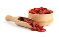 Wooden bowl and scoop of tasty dried goji berries Royalty Free Stock Photo