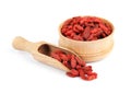 Wooden bowl and scoop of tasty dried goji berries on white Royalty Free Stock Photo