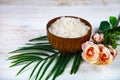 Wooden bowl with sea salt, rose and palm leaf Royalty Free Stock Photo